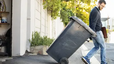 Man rollwing waste cart 