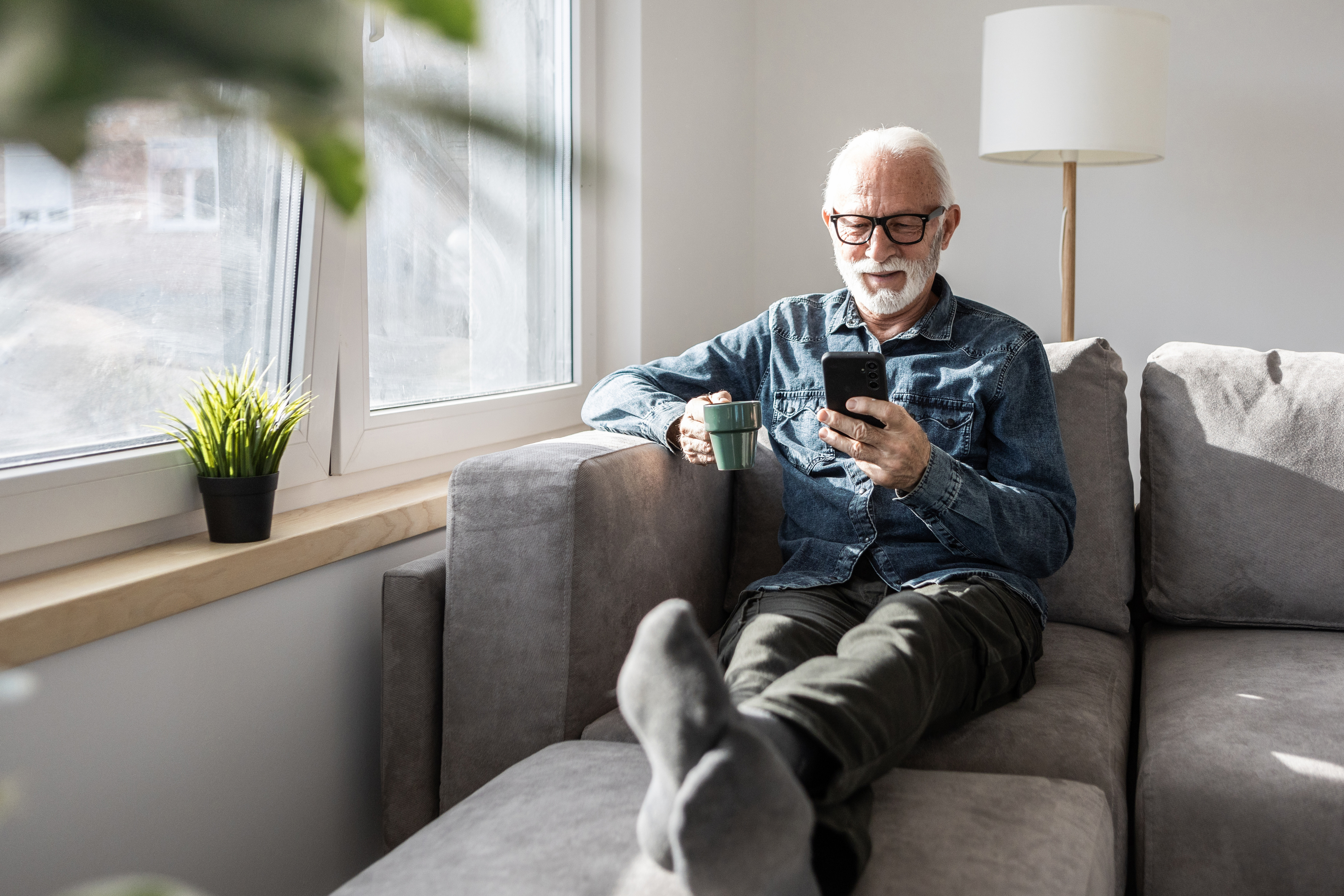 Older man reading news on his phone